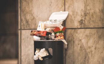 black trash bin with full of trash