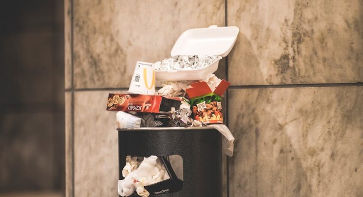 black trash bin with full of trash